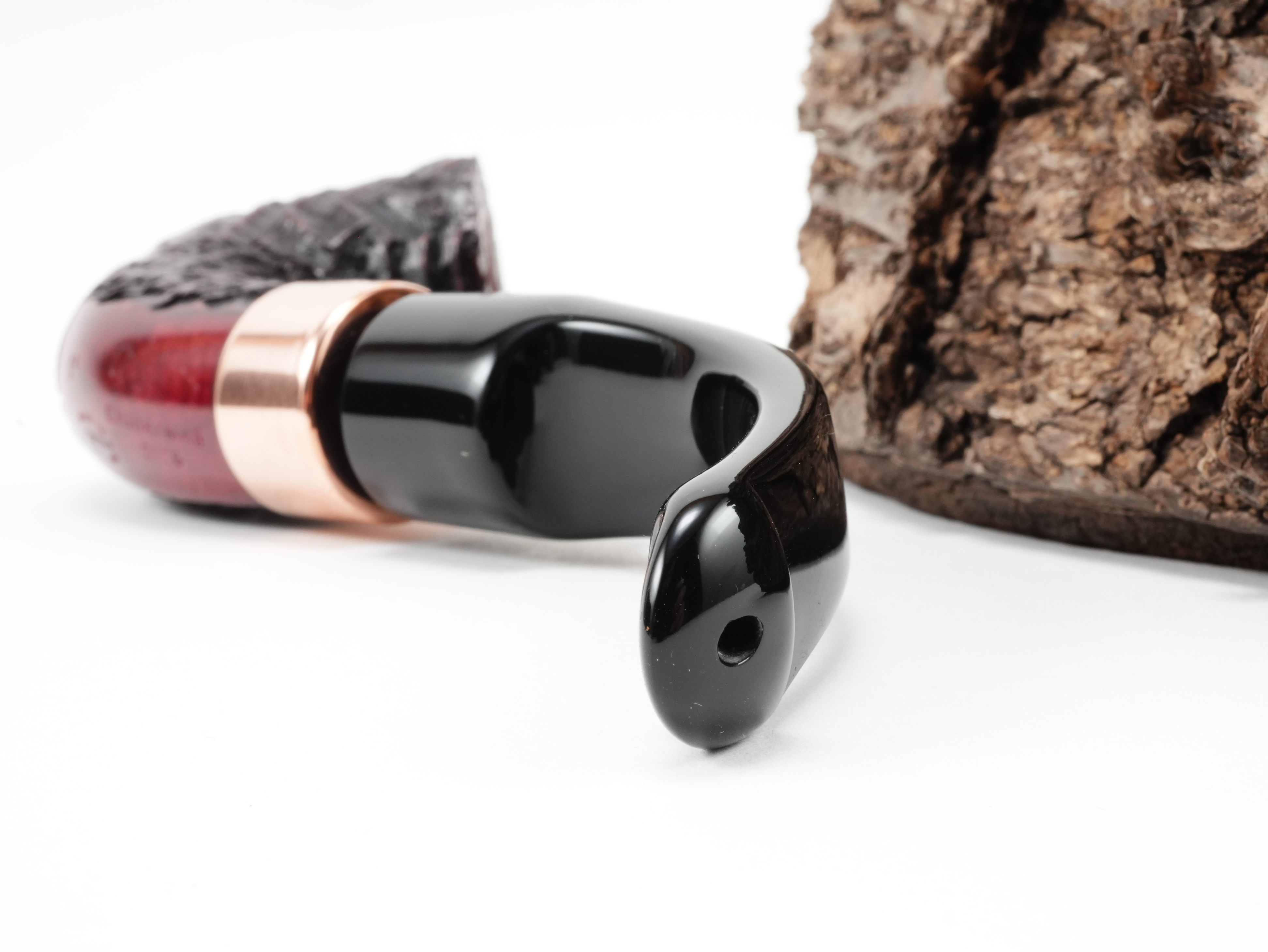 Nahaufnahme des gebogenen schwarzen Acrylmundstücks der Peterson Christmas 2026 Rustic 5s Pfeife mit Lippenbissöffnung von hinten