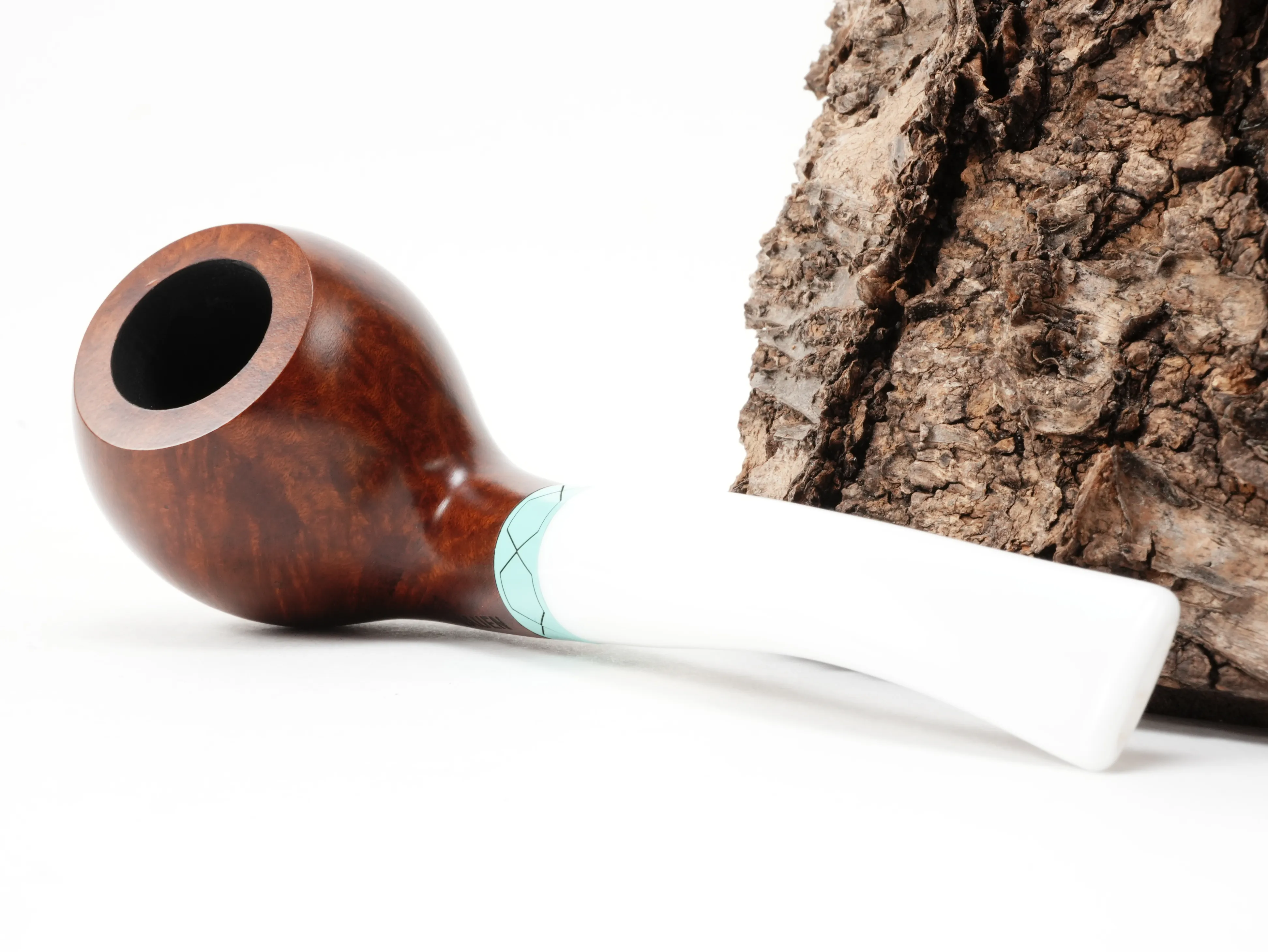 Vauen VELA 2442 Ball-Pfeife liegend von schräg hinten mit türkisgrünem Ring im Sechseckmuster und weißem Acrylmundstück