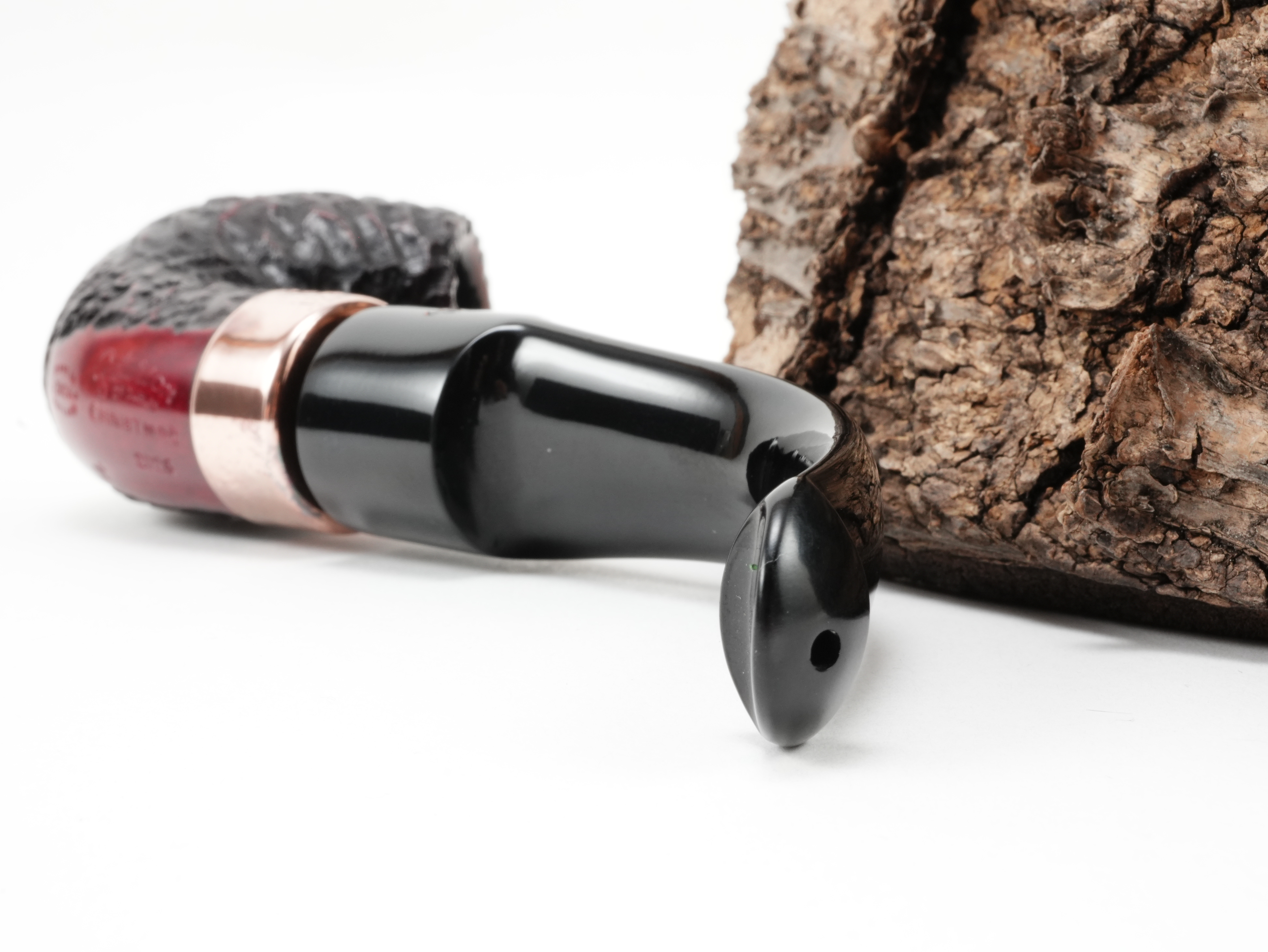 Nahaufnahme des gebogenen schwarzen Ebonitmundstücks der Peterson Christmas 2026 Rustic 11s Pfeife mit Lippenbissöffnung von hinten