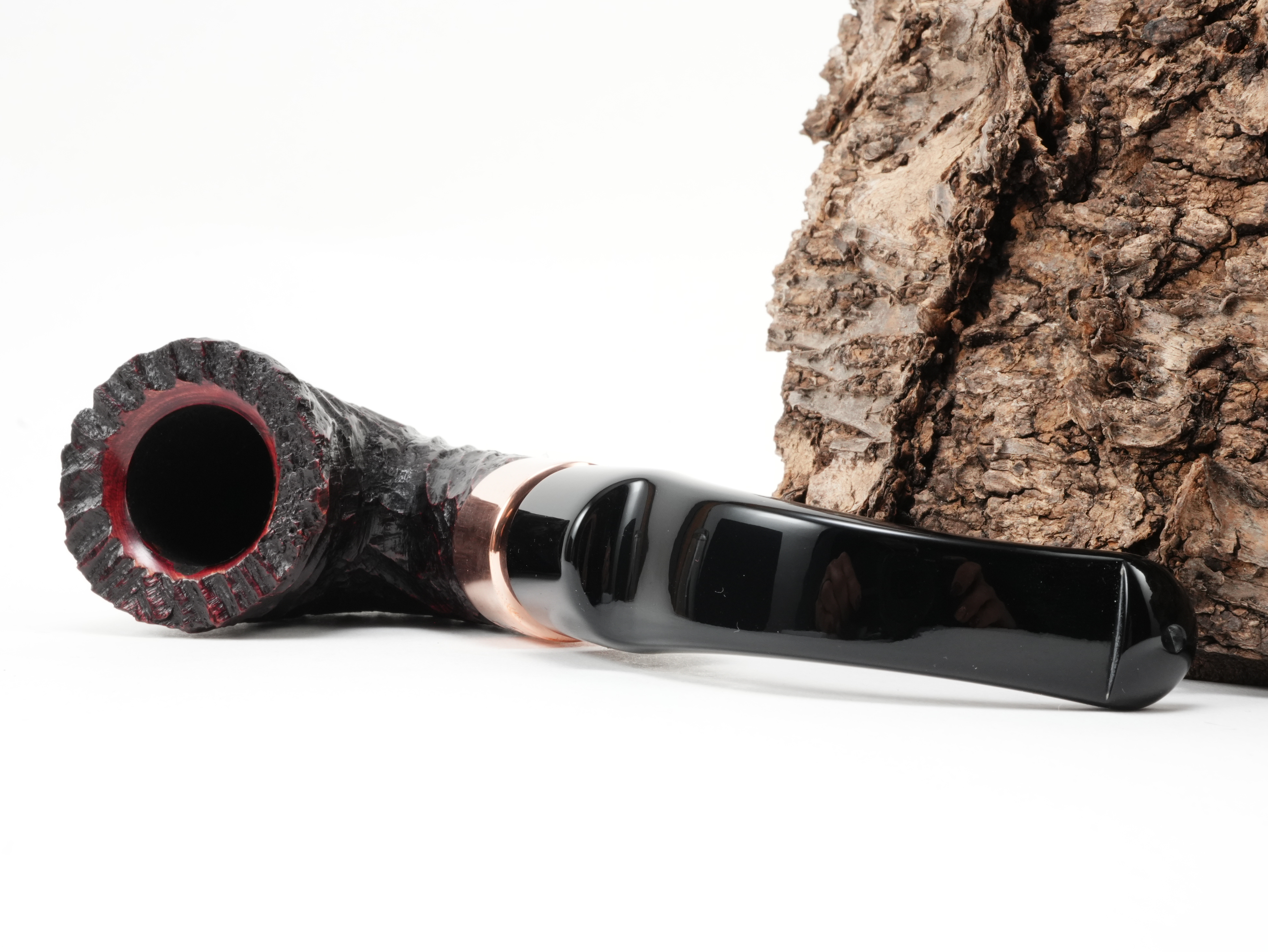 Peterson Christmas 2026 Rustic 5s Bent Calabash Pfeife liegend von schräg hinten mit Fokus auf die glänzende K&P Kupferapplikation am Holm