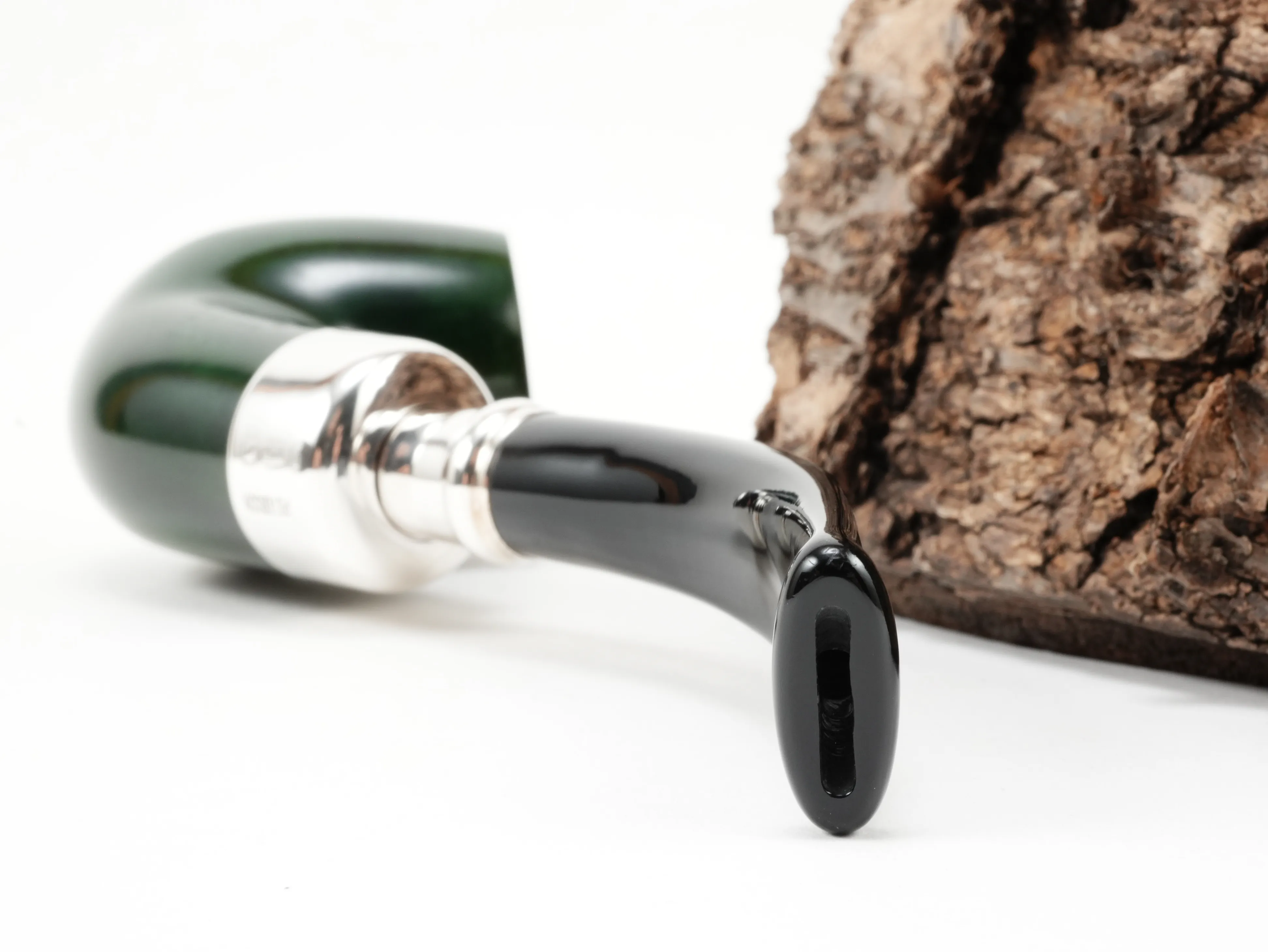 Nahaufnahme des gebogenen schwarzen Acrylmundstücks der Peterson Spigot Green XL90 Pfeife mit Spigot-Silberansatz und Bissstelle von hinten