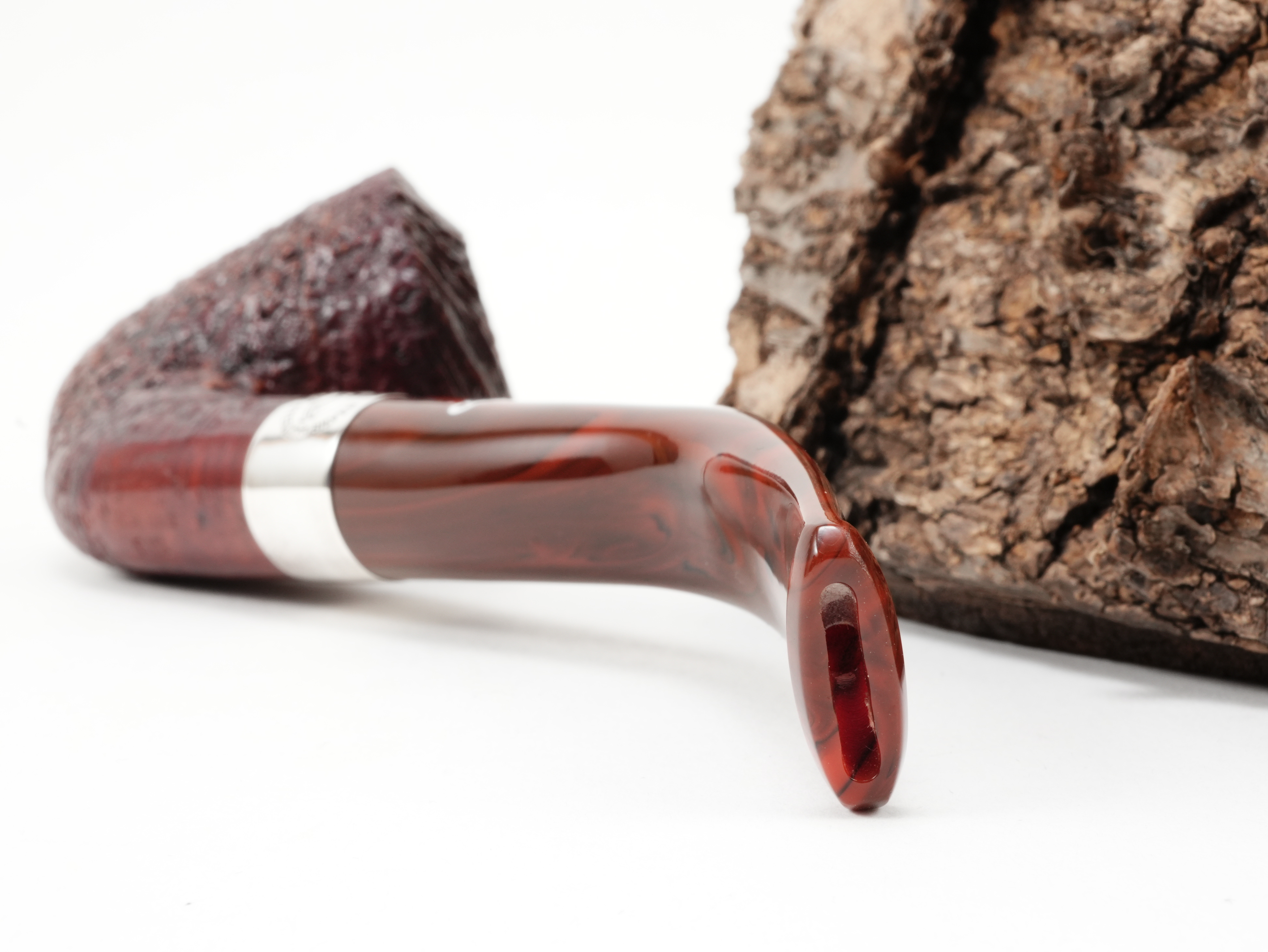 Nahaufnahme des gebogenen rot-marmorierten Acrylmundstücks der Peterson Irish Harp B10 Sand Pfeife mit Bissstelle von hinten