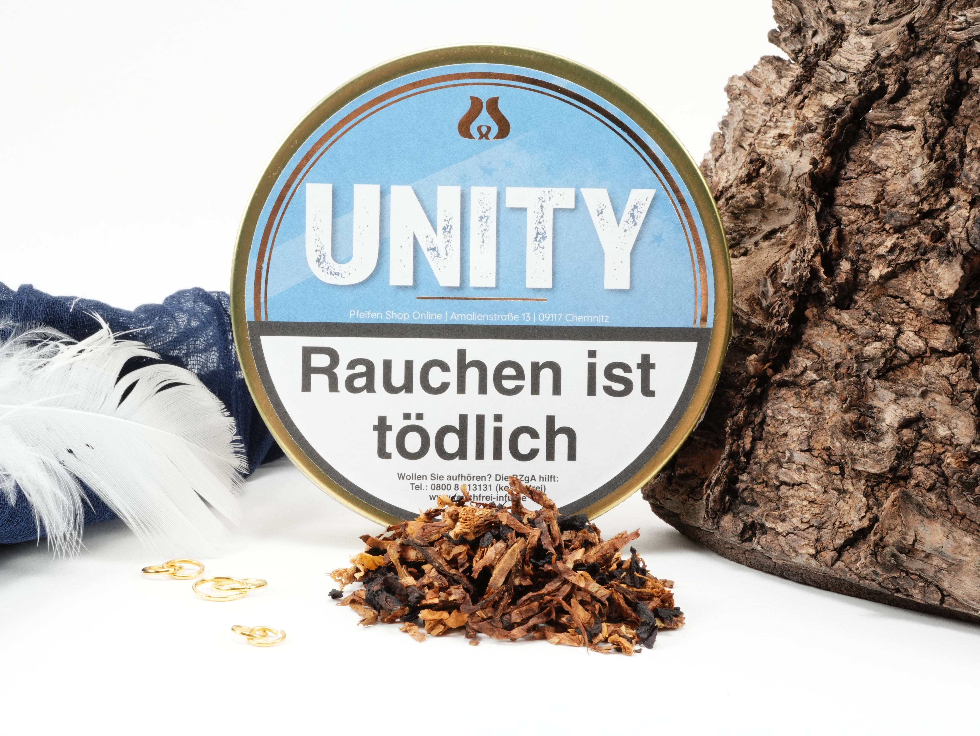 Pfeifentabak UNITY 50g Dose der Eigenmarke im hellblauen Design stehend vor Dekoration – Titelbild