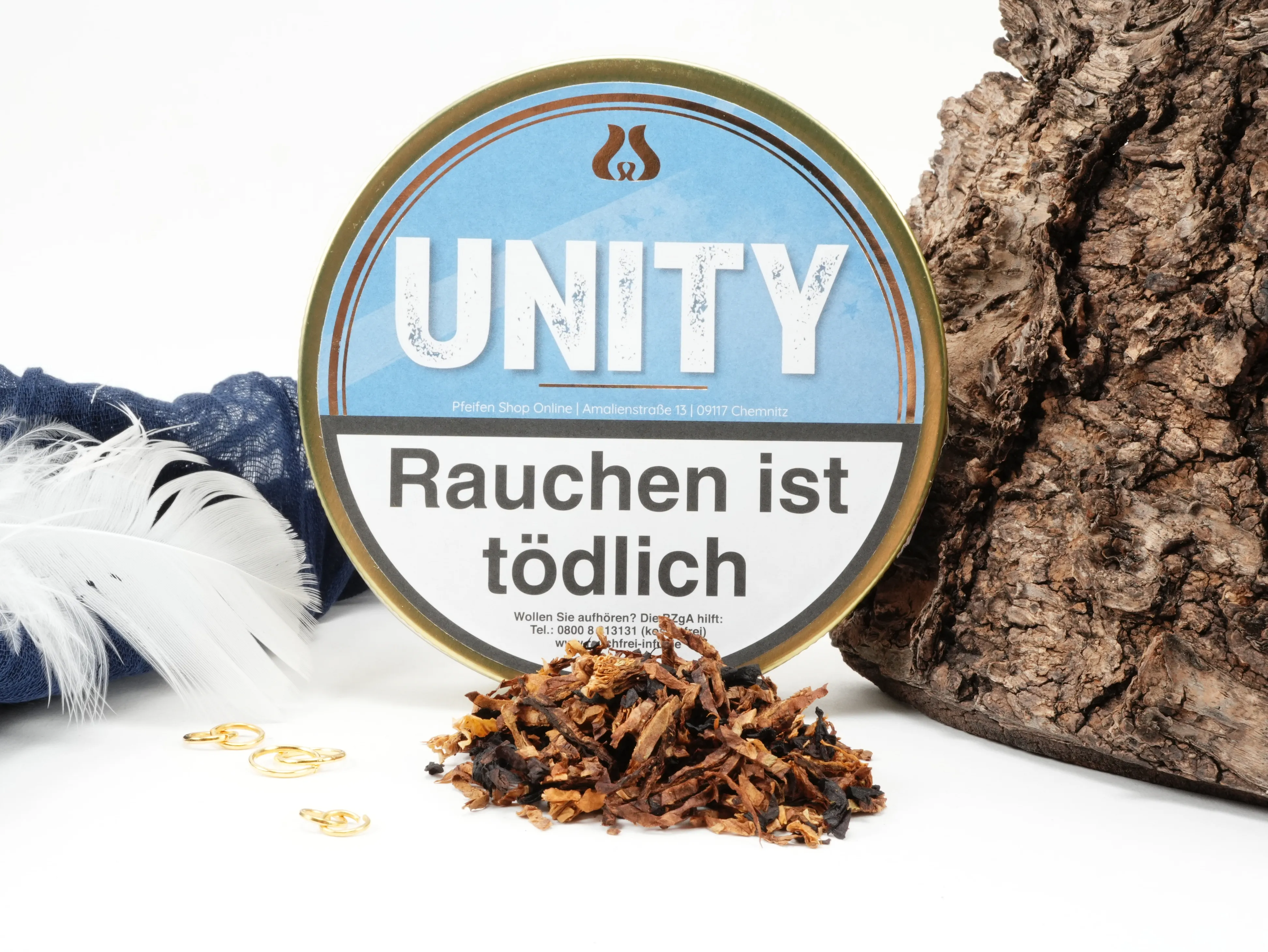 Pfeifentabak UNITY 50g Dose der Eigenmarke im hellblauen Design stehend vor Dekoration – Titelbild