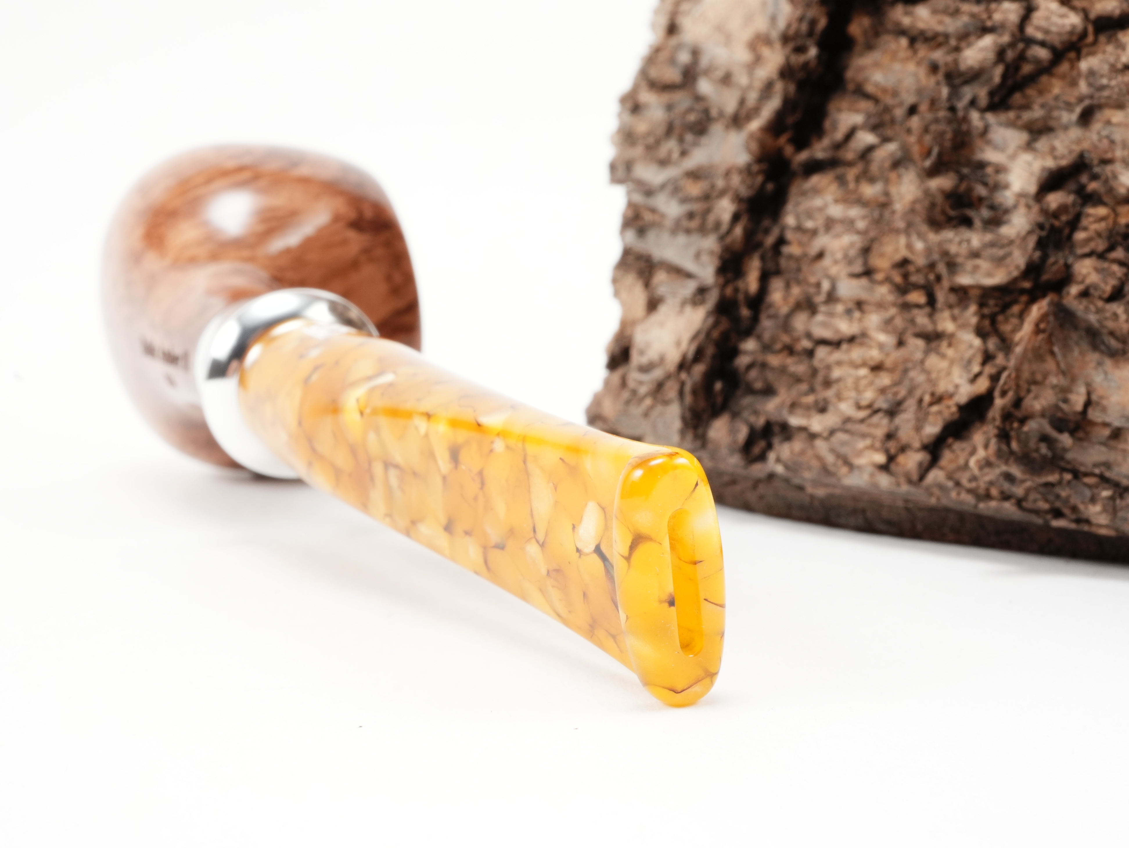 Nahaufnahme des geraden bernsteinfarbenen Acrylmundstücks der db Design Berlin Baltic Amber II 034 Pfeife mit trichterförmigem Metallring und Bissstelle von hinten