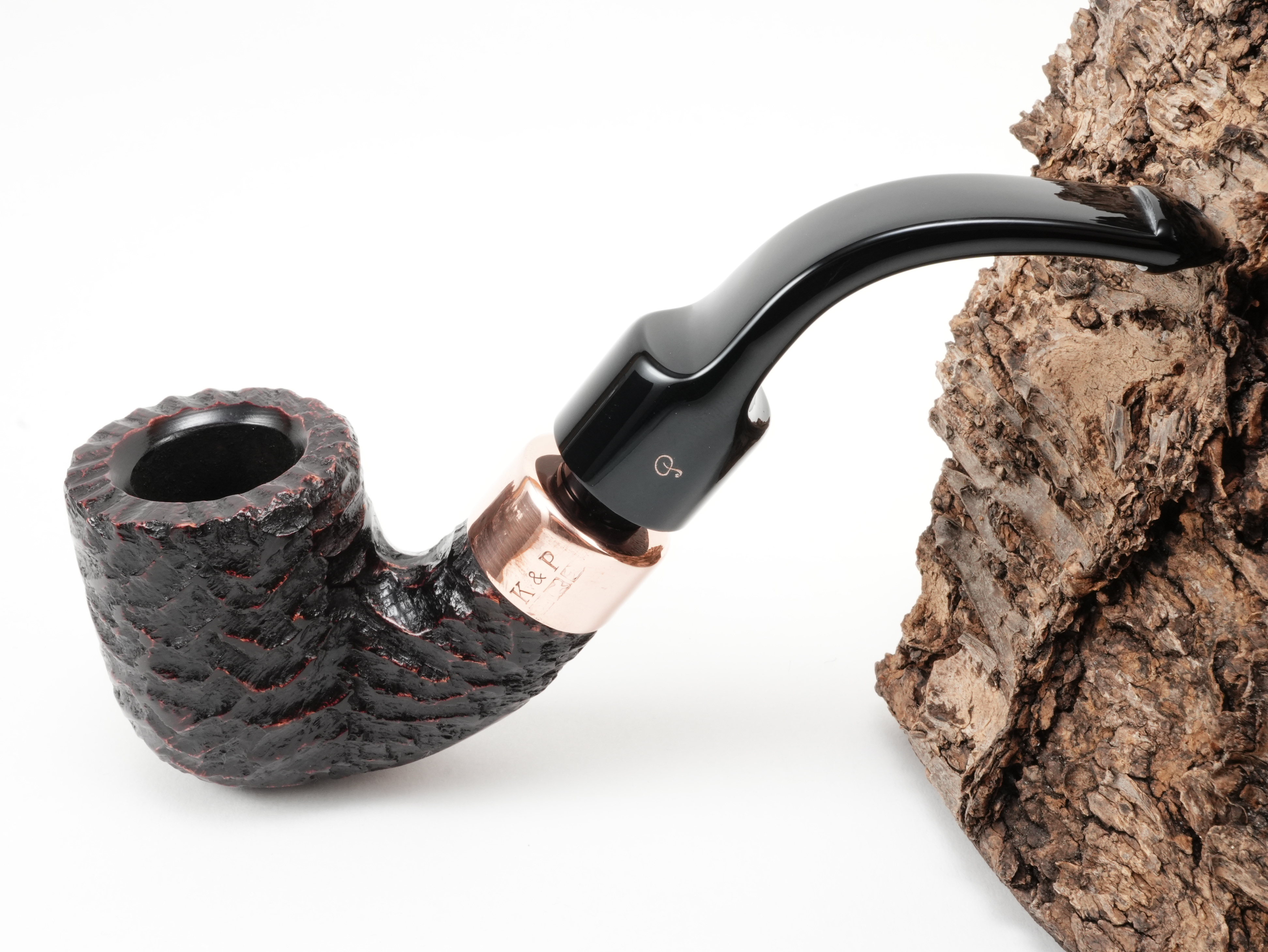 Rotbraun rustizierte Peterson Christmas 2026 Rustic 1s Pfeife Bent Classic mit K&P Kupferring und kupferfarbenem P-Logo am Lippenbissmundstück – Titelbild schräg von oben