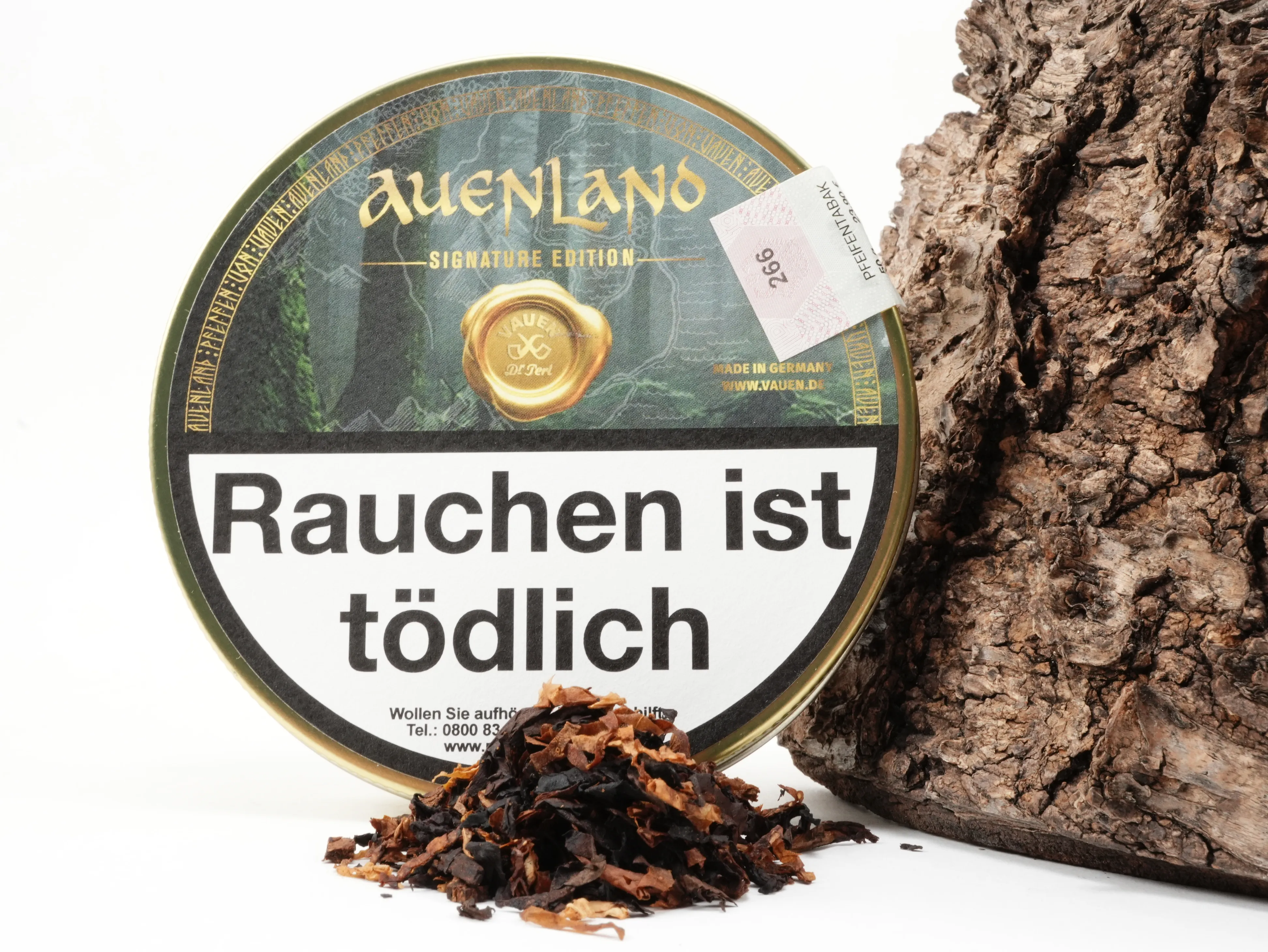 Frontansicht der runden Vauen Auenland Signature Edition Tabakdose mit Siegel-Logo und Auenland-Motiv vor Baumrinde