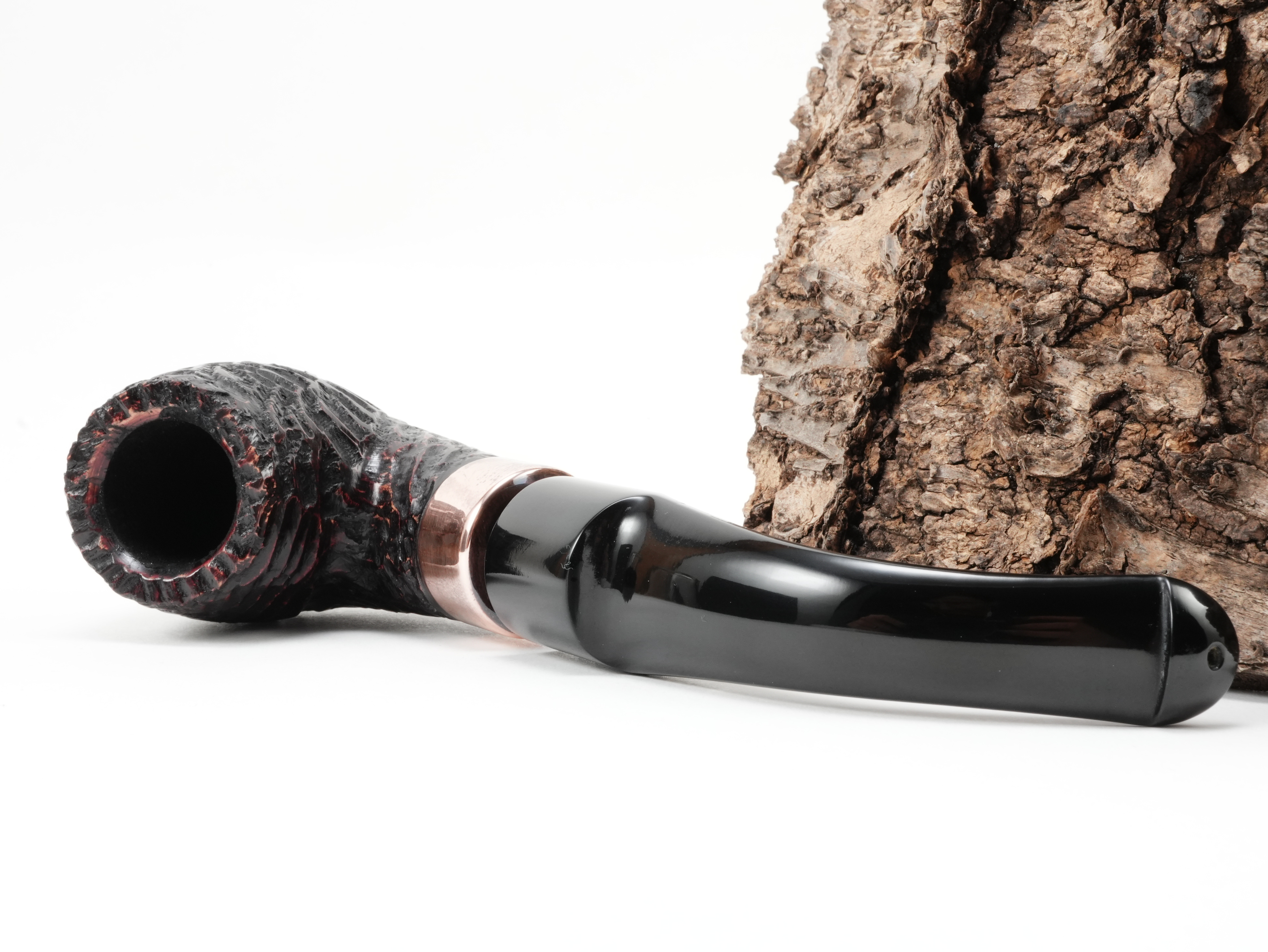 Peterson Christmas 2026 Rustic 9s Half-Bent Classic Pfeife liegend von schräg hinten mit Fokus auf die glänzende K&P Kupferapplikation am Holm
