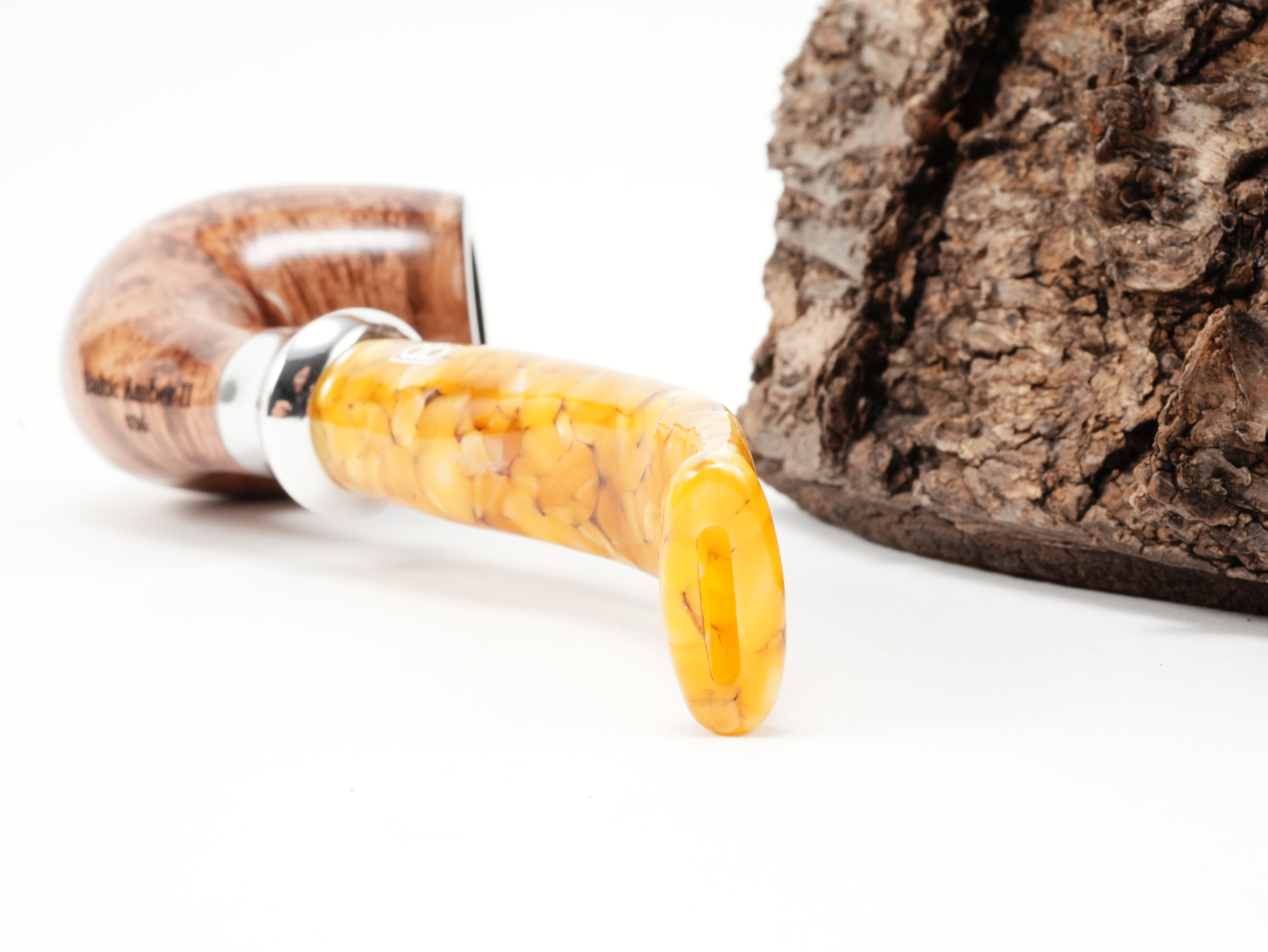 Nahaufnahme des gebogenen bernsteinfarbenen Acrylmundstücks der db Design Berlin Baltic Amber II 036 Pfeife mit trichterförmigem Metallring und Bissstelle von hinten