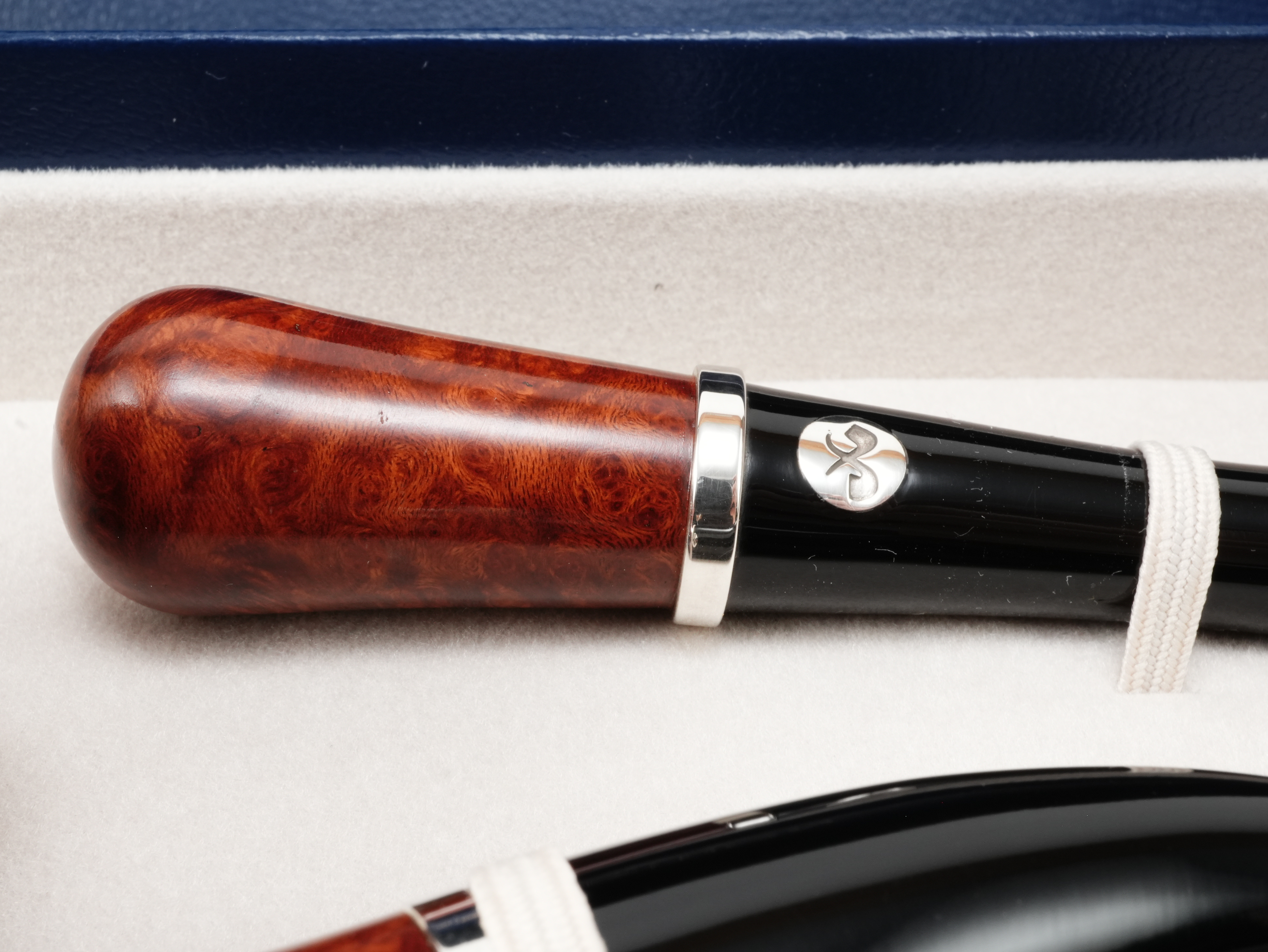 Nahaufnahme des passenden Vauen Tradition Pfeifenstopfers aus Bruyèreholz und schwarzem Acryl mit Sterling-Silberlogo