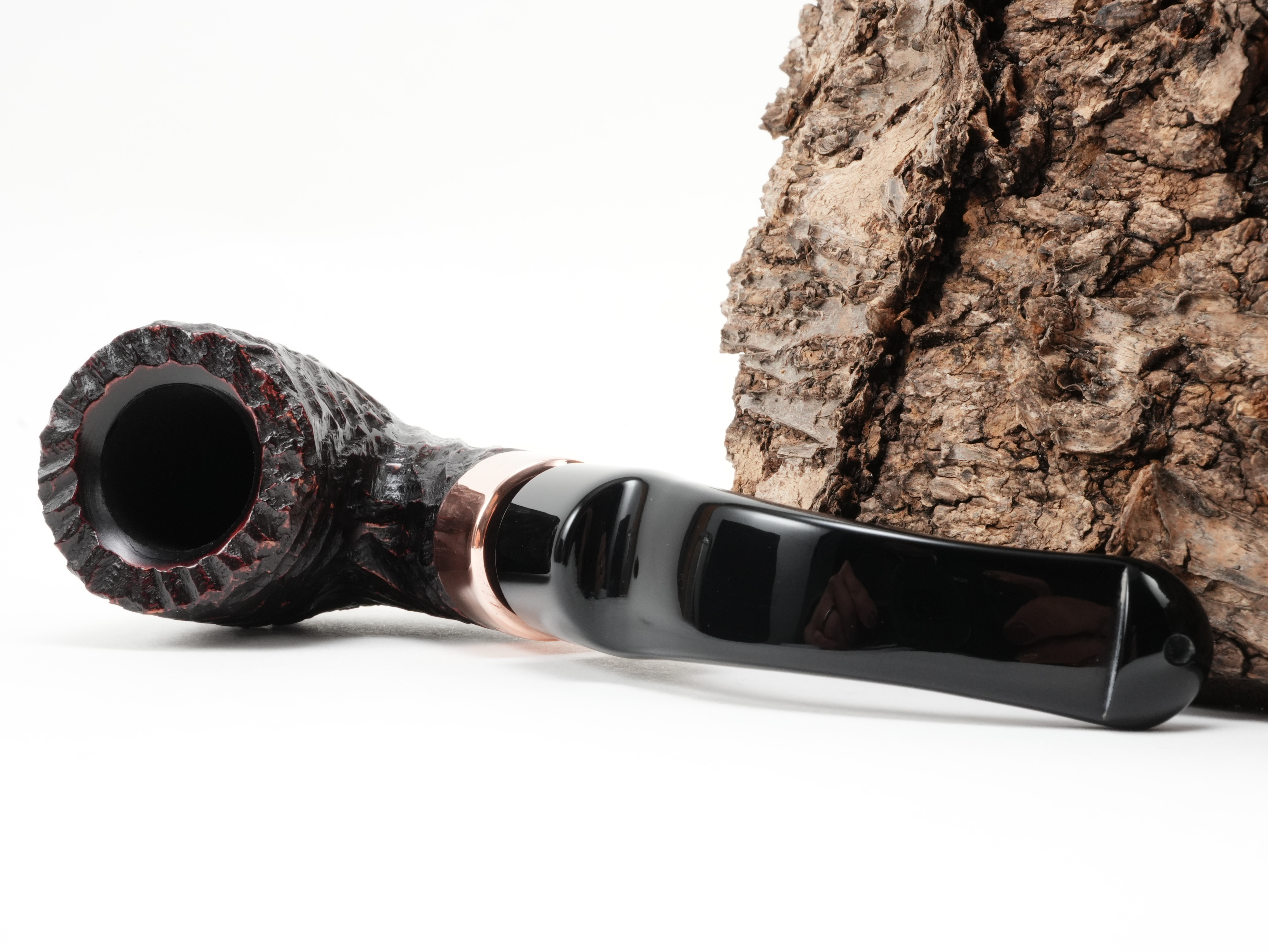 Peterson Christmas 2026 Rustic 1s Bent Classic Pfeife liegend von schräg hinten mit Fokus auf die glänzende K&P Kupferapplikation am Holm