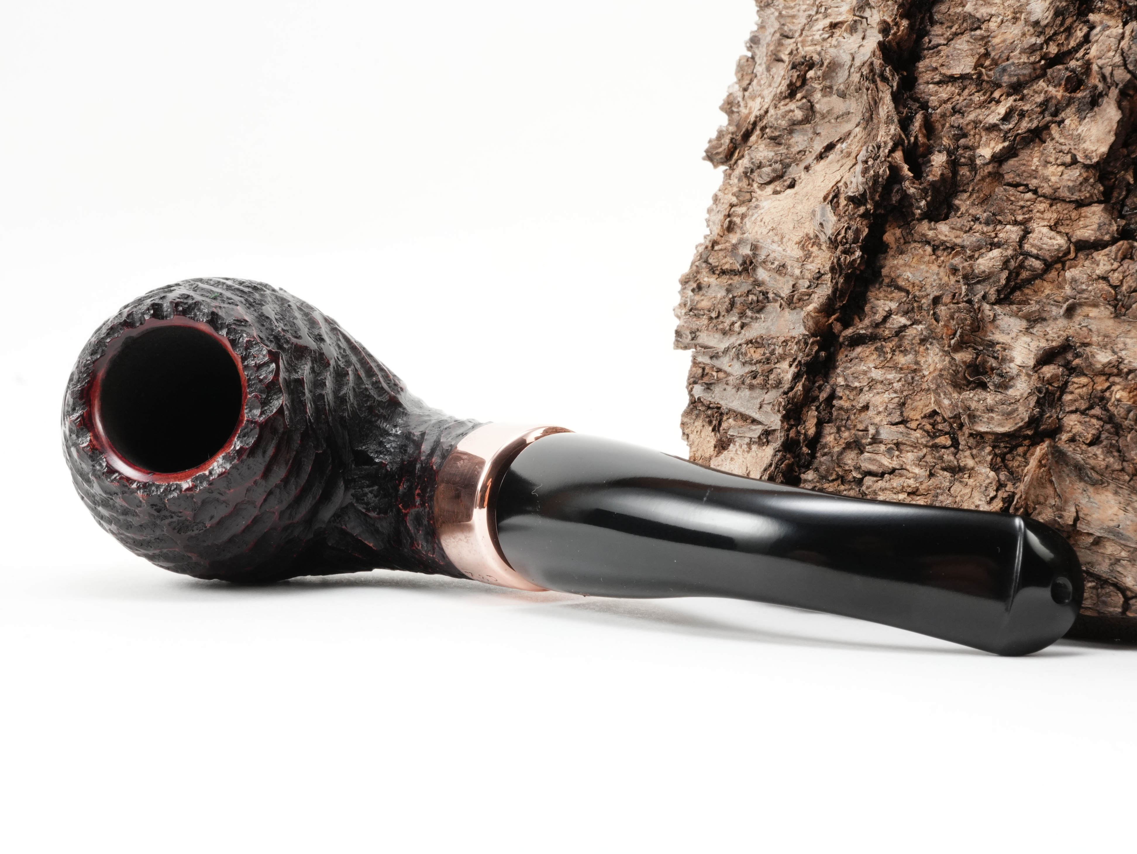 Peterson Christmas 2026 Rustic B42 Bent Apple Pfeife liegend von schräg hinten mit Fokus auf die glänzende K&P Kupferapplikation am Holm