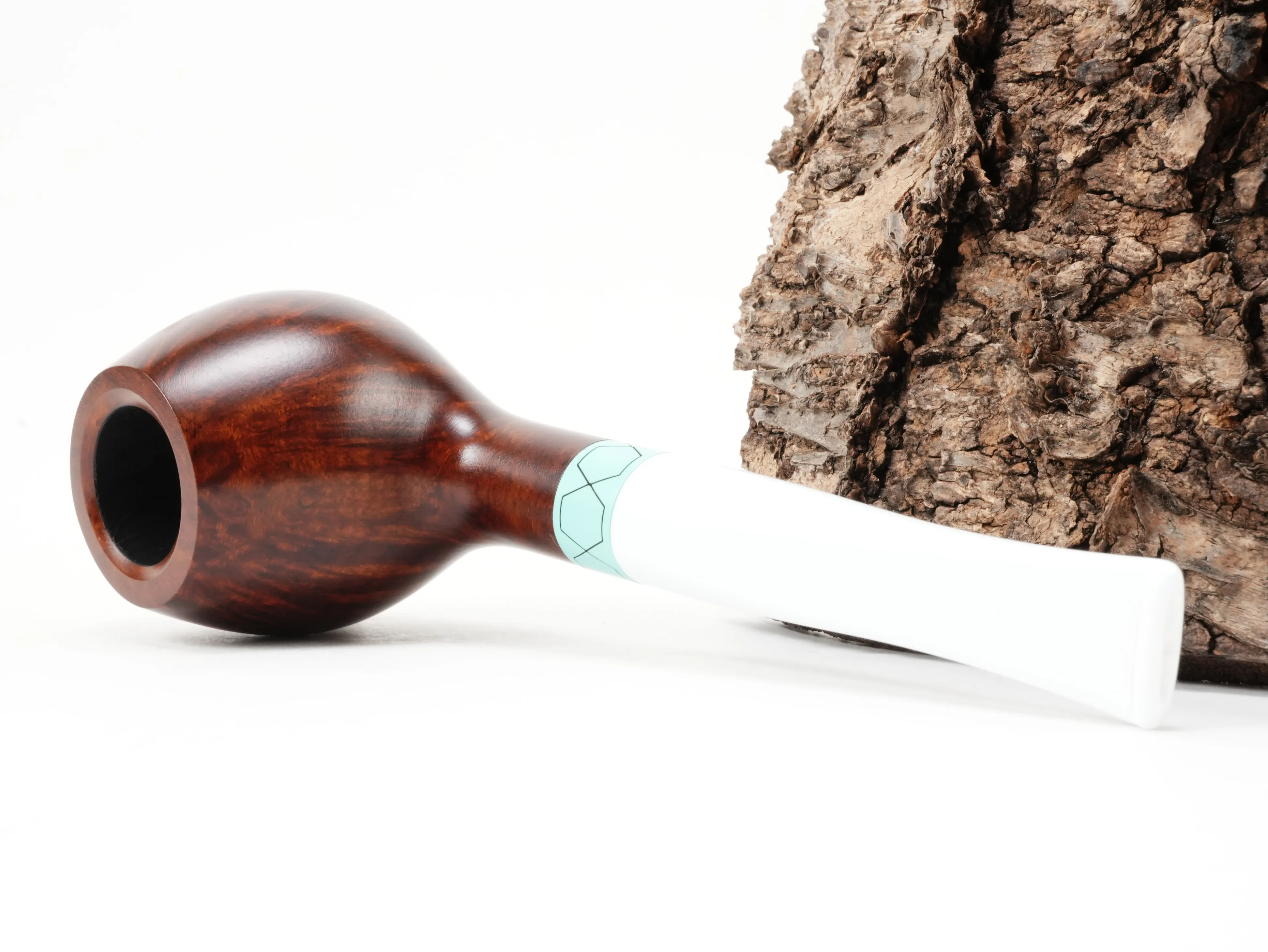 Vauen VELA 2431 Brandy-Pfeife liegend von schräg hinten mit türkisgrünem Ring im Sechseckmuster und weißem Acrylmundstück