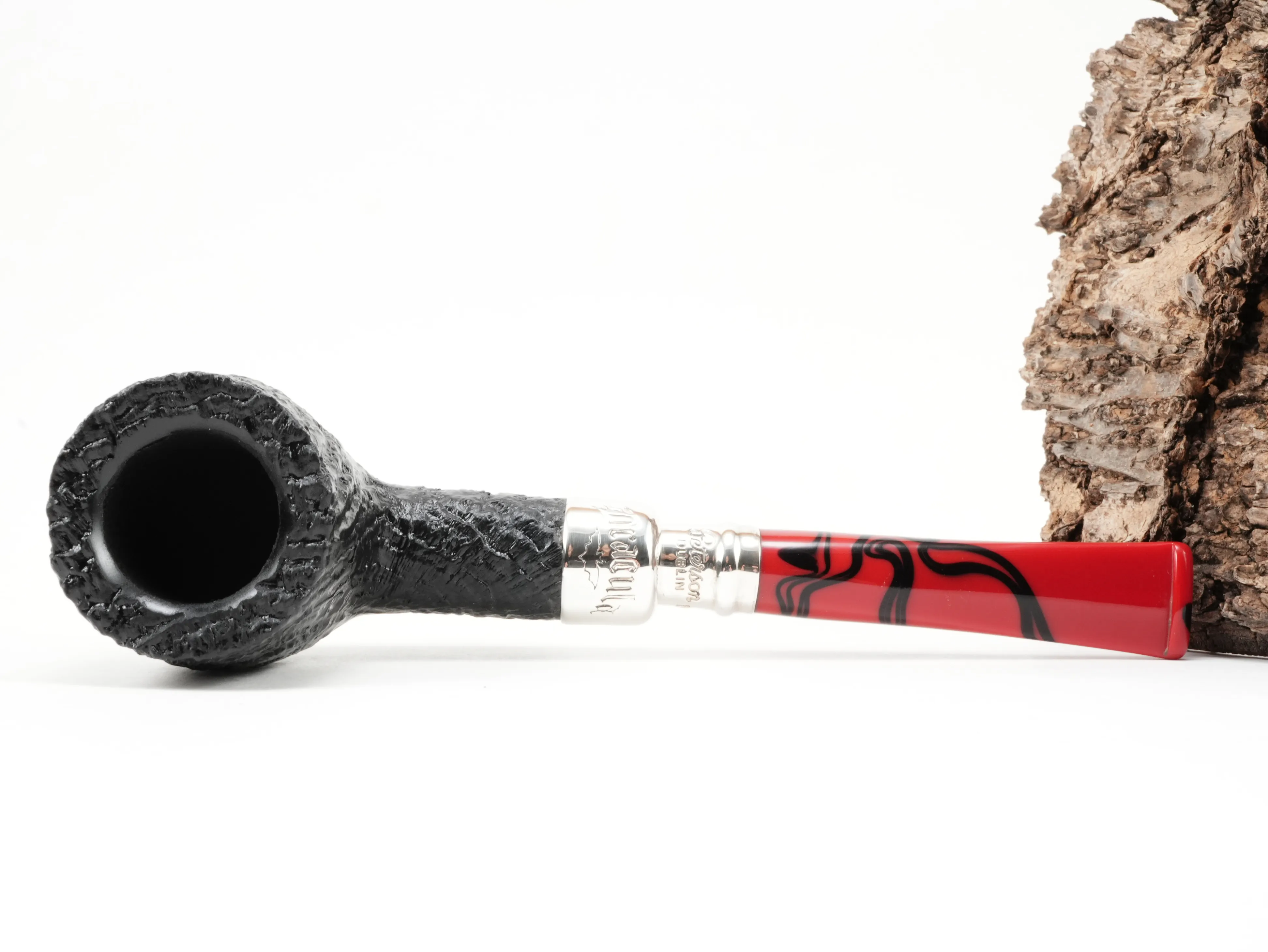 Flache Draufsicht auf die liegende Peterson Dracula Spigot Sand 106 Pfeife mit Fokus auf den schwarz sandgestrahlten Pfeifenkopf