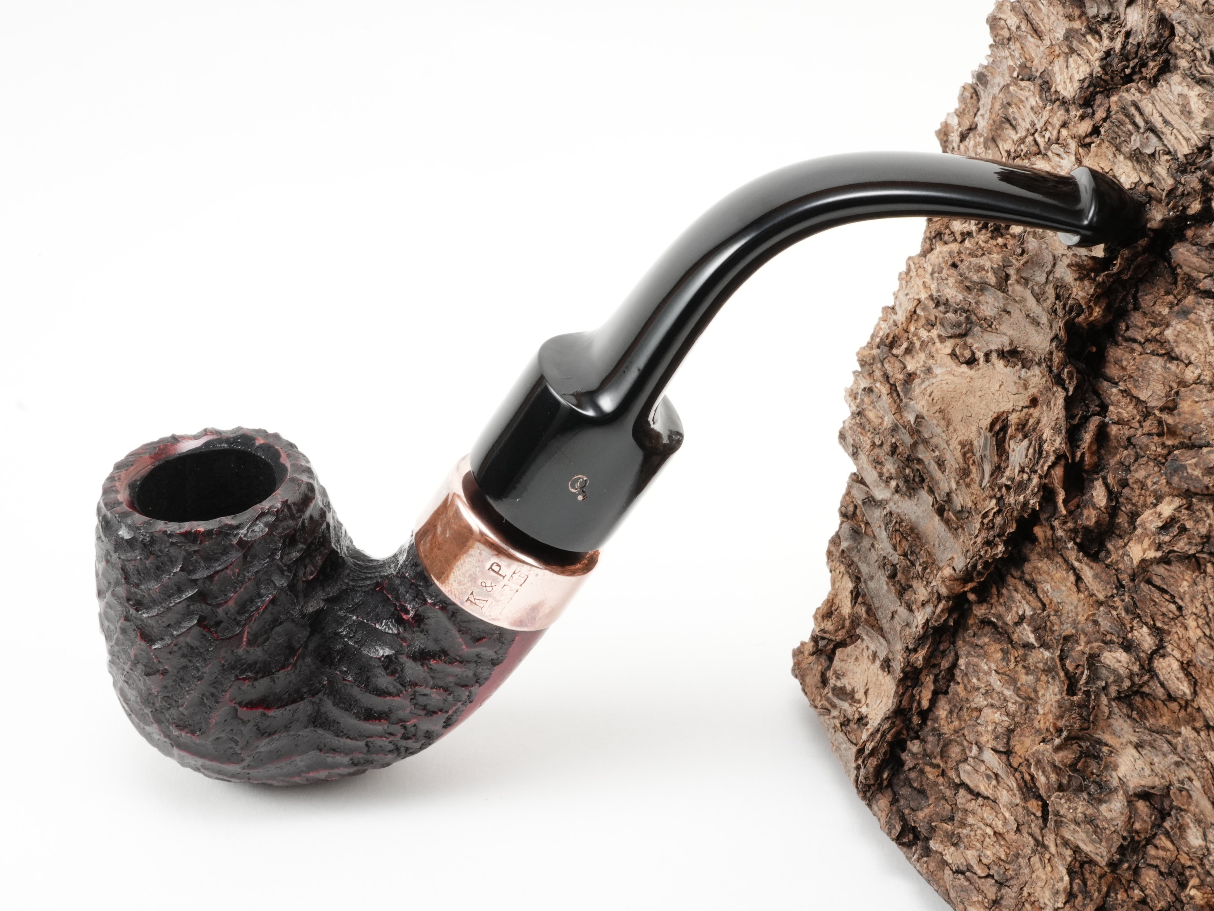 Rotbraun rustizierte Peterson Christmas 2026 Rustic 11s Pfeife Bent Classic mit K&P Kupferring und kupferfarbenem P-Logo am Ebonit-Lippenbissmundstück – Titelbild schräg von oben