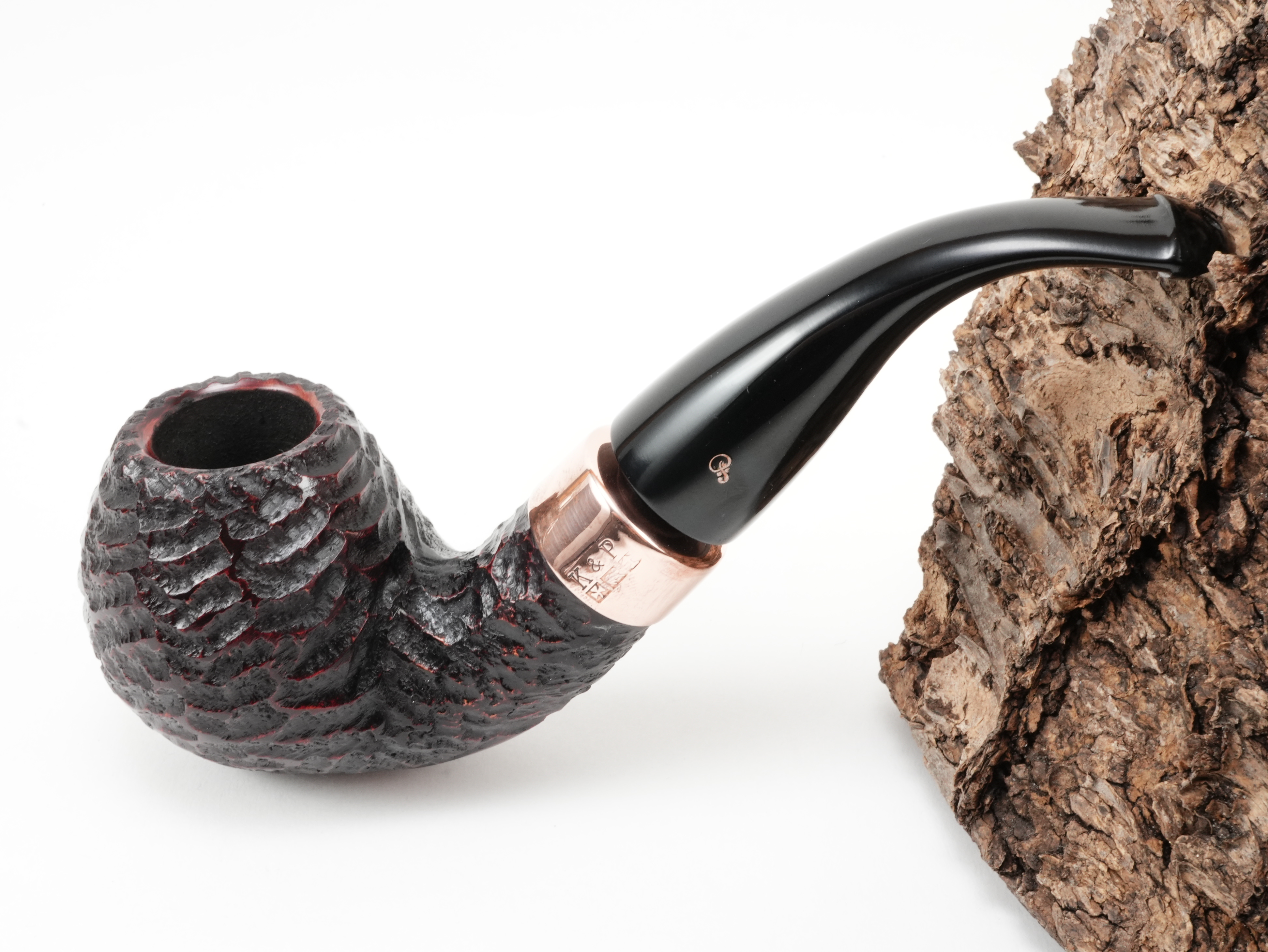 Rotbraun rustizierte Peterson Christmas 2026 Rustic B42 Pfeife Bent Apple mit K&P Kupferring und kupferfarbenem P-Logo am Ebonit-Lippenbissmundstück – Titelbild schräg von oben