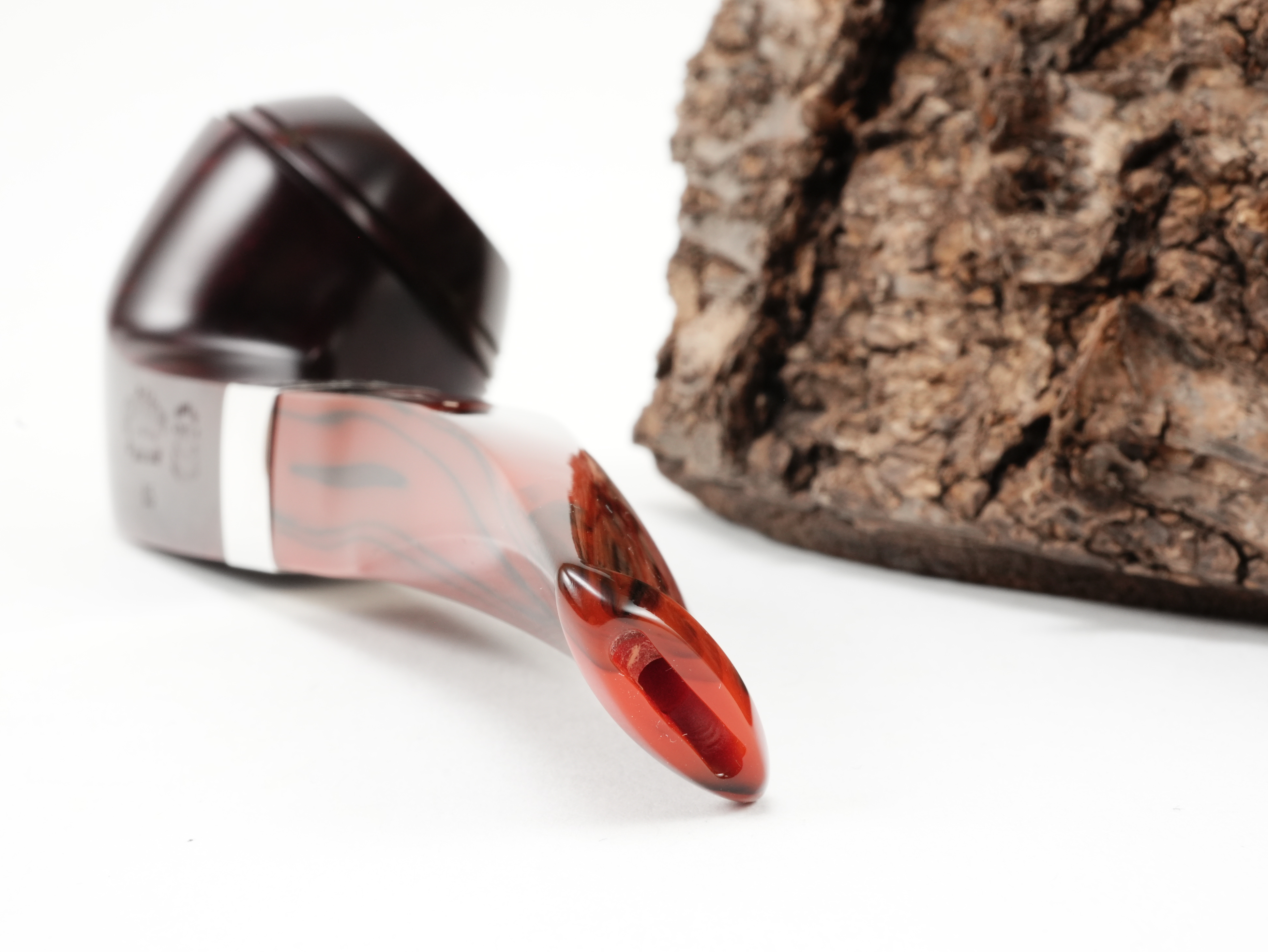 Nahaufnahme des gebogenen rot-marmorierten Acrylmundstücks der Peterson Irish Harp B5 Brown Pfeife mit Bissstelle von hinten