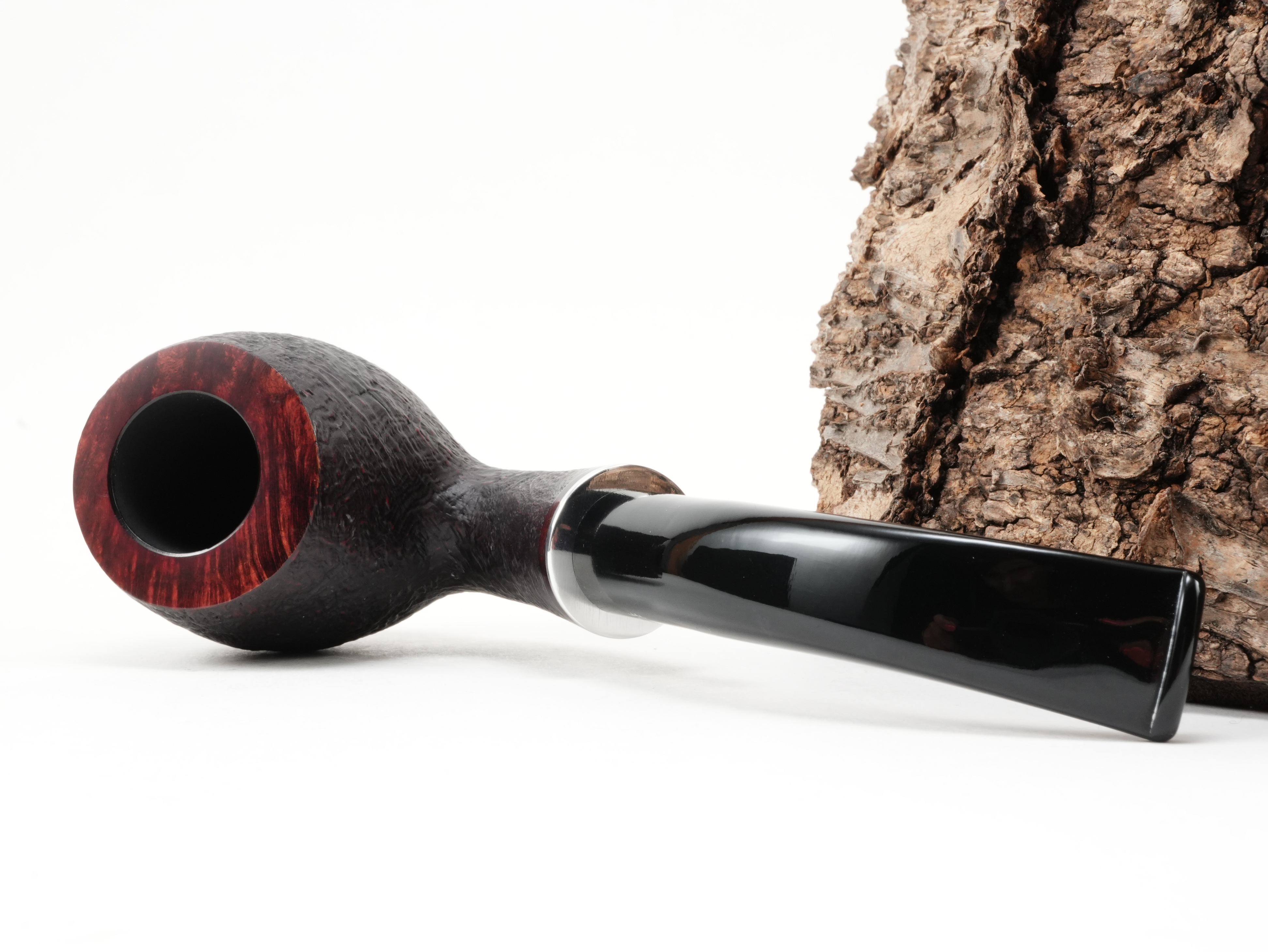 Stanwell H.C. Andersen Sandblasted 7 Pfeife liegend von schräg hinten mit glänzendem Metallring und sandgestrahlter Oberflächenstruktur
