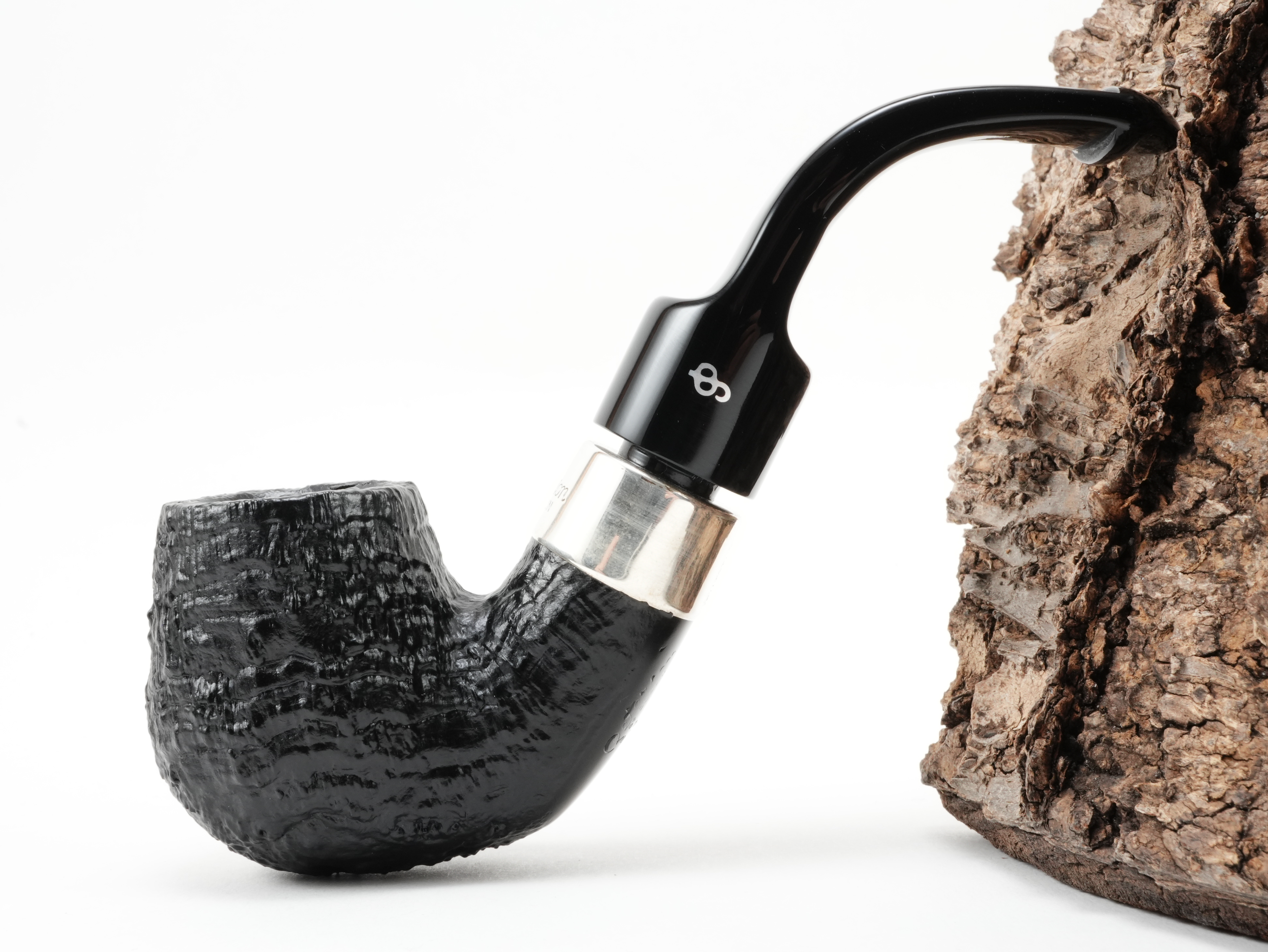 Peterson Deluxe System 20s PL sand Pfeife exakte Seitenansicht mit tief sandgestrahltem Pfeifenkopf, Silber-Manschette und gebogenem schwarzem Acrylmundstück mit Logo