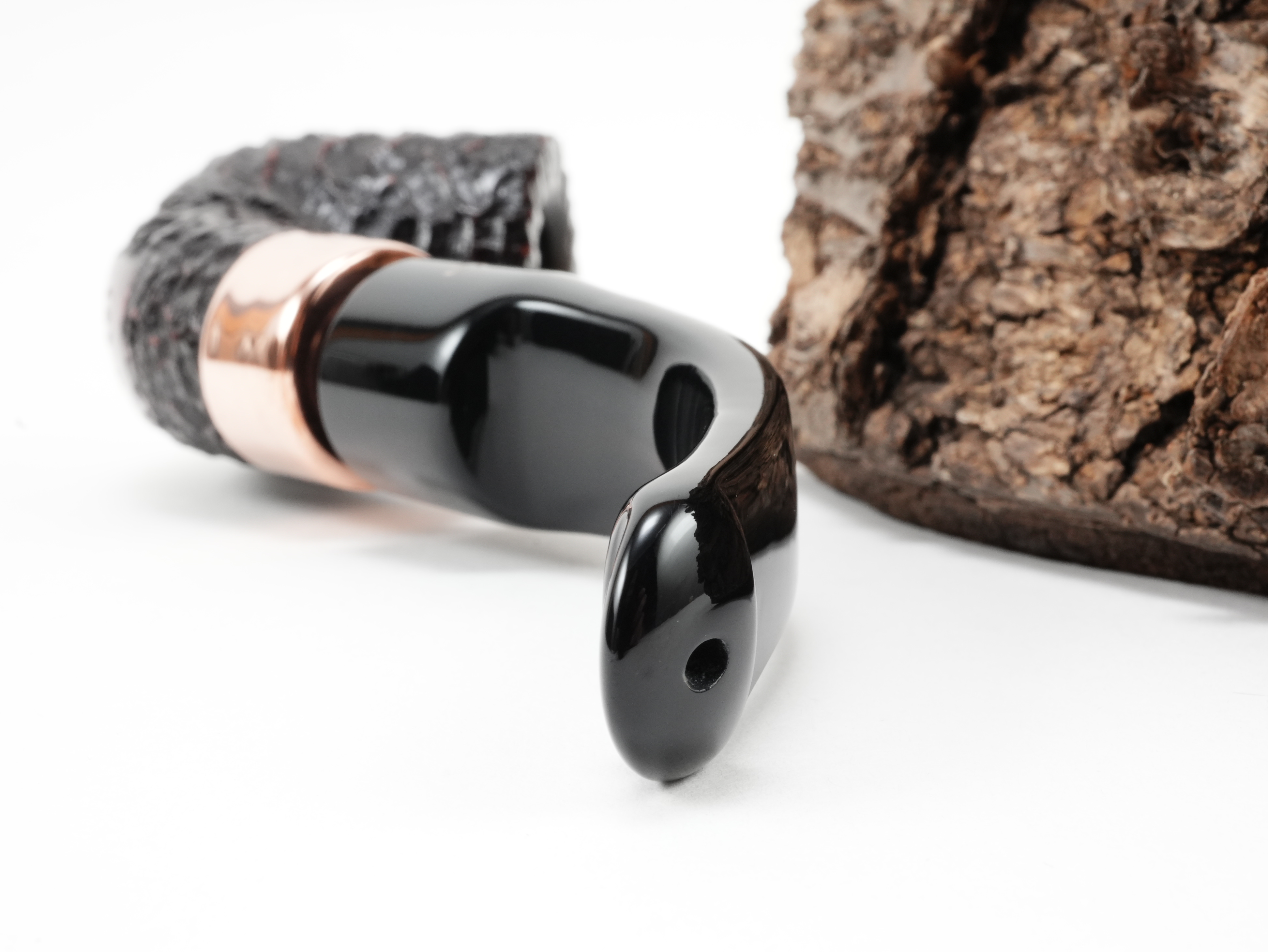 Nahaufnahme des gebogenen schwarzen Acrylmundstücks der Peterson Christmas 2026 Rustic 1s Pfeife mit Lippenbissöffnung von hinten
