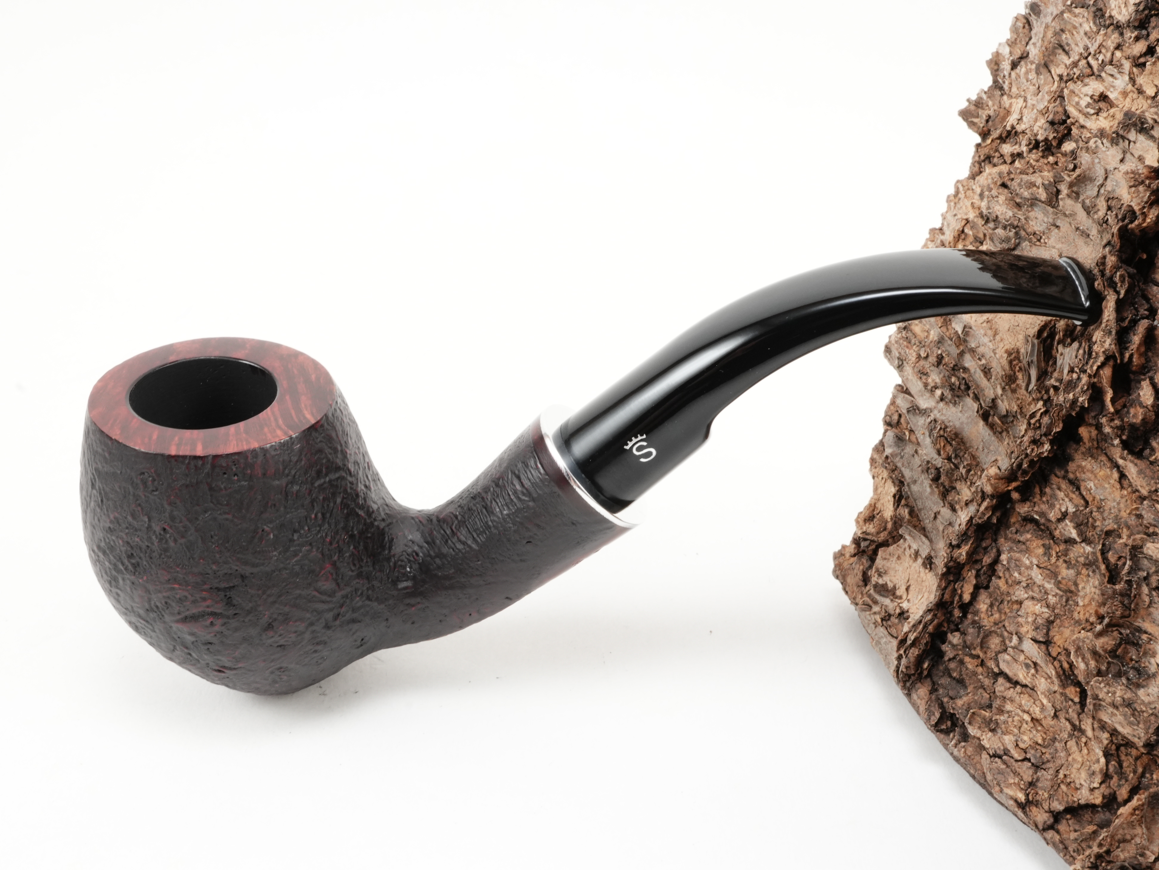 Dunkel-rötlich sandgestrahlte Stanwell H.C. Andersen Sandblasted 7 Bent-Pfeife mit rötlich-glattem Kopfrand und kurzem Acrylmundstück – Titelbild schräg von oben